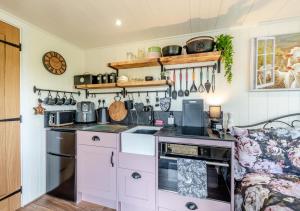 a kitchen with a stove top oven next to a couch at Little Bo Peep in Fremington