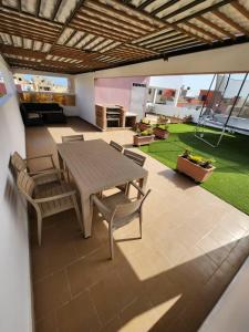 a patio with a wooden table and chairs at Piscine privative et prestations haut de gamme in Dakar