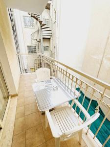 a white table and chairs on a balcony at Stephanie City Apartments in Larnaka