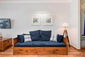 un divano blu in soggiorno di Studio Apartment Villa Mistral Świnoujście by Renters a Świnoujście