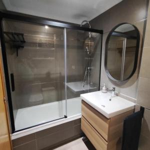Un baño con ducha, lavabo y espejo. en Piso céntrico en Viveiro con aparcamiento, en Viveiro 14 fotos más