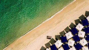 una vista aérea de una playa con sombrillas azules y blancas en Avaton Luxury Beach Resort - Relais & Chateaux, en Ouranoupoli