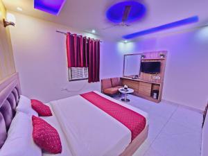 Hotel Gross International near delhi airport في نيودلهي: غرفة نوم بسرير كبير وتلفزيون
