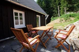 una mesa de madera y sillas en un patio en Ferienhaus Anno Dazumal wie zu Opa`s Zeiten en Klingenthal