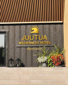 ein Jupiter-Wildnis-Hotel-Schild auf der Vorderseite eines Gebäudes in der Unterkunft Wilderness Hotel Juutua in Inari