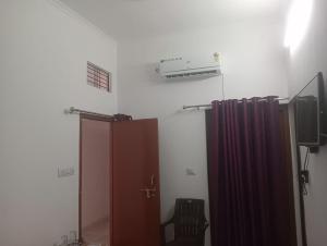 um quarto com uma televisão, uma porta e uma televisão em Maa vaishno paying guest house em Ayodhya