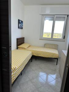 twee bedden in een kamer met twee ramen bij Antonio's Home in Bari