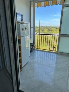 eine Küche mit einem Kühlschrank und einen Balkon mit Aussicht in der Unterkunft Antonio's Home in Bari
