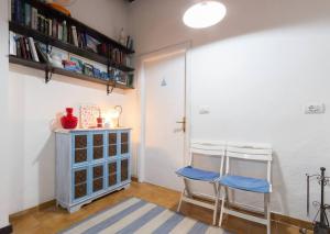 ポモンテにあるLa Pergola di Pomonteの椅子2脚と本が入ったキャビネットがある部屋