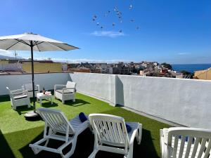 a group of chairs and an umbrella on a roof at La Cala de Alcalá Luxury in Alcalá