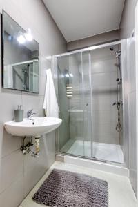 ein Bad mit einem Waschbecken und einer Glasdusche in der Unterkunft GC1 - Lovely 2 Bed Apt in Gzira in Gżira