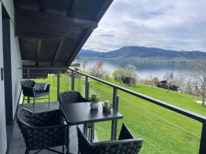 a balcony with a table and chairs and a view of a lake at Ferienwohnung Gaigg in Weyregg