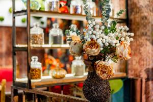 un vaso pieno di fiori in cima a uno scaffale di Tiflis Inn Boutique Hotel a Tbilisi City