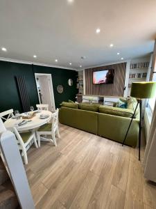 uma sala de estar com um sofá verde e uma mesa em KILEX House Bedlinog - Rock Summit Climbing, Bike Park Wales, Zip World Tower, Brecon Beacons, Eisteddfod, Contractors em Bedlinog