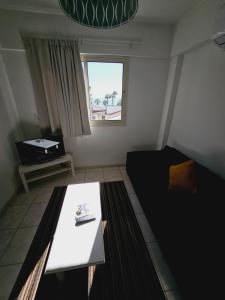 sala de estar con mesa y ventana en Stephanie City Apartments, en Lárnaca