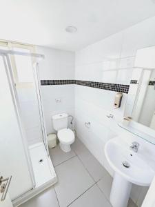 Baño blanco con aseo y lavamanos en Stephanie City Apartments, en Lárnaca