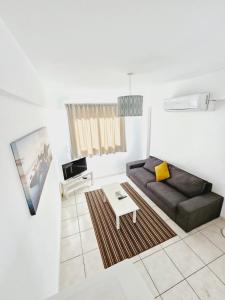 a living room with a couch and a coffee table at Stephanie City Apartments in Larnaca