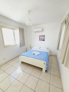 1 dormitorio con 1 cama en una habitación blanca en Stephanie City Apartments, en Lárnaca