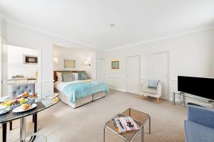 Habitación de hotel con cama y TV en Nell Gwynn Chelsea Accommodation en Londres
