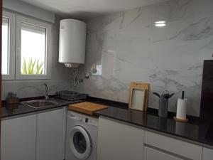 a kitchen with a sink and a washing machine at Rayos de Sol in Peñíscola