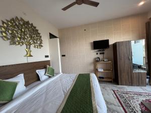 阿爾莫拉的住宿－The Himalayan Heights Satya's kasardevi，卧室配有一张床铺,墙上挂着一棵树