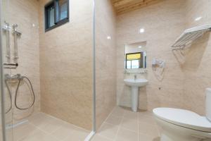 a bathroom with a shower and a toilet and a sink at EZE Homestay in Ji'an