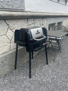 een grill die naast een tafel tegen een muur staat bij Lakeview House in Horgen