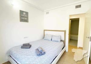 ein weißes Schlafzimmer mit einem Bett mit blauen Bogen darauf in der Unterkunft CostaBlancaDreams Spanish Dream in Calpe in Calpe + 11 Fotos