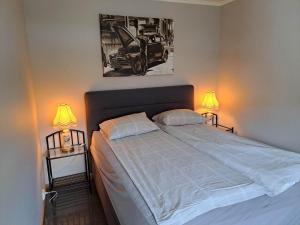 a bedroom with a large bed with two lamps at Apartment Tryms vei 20a - Elegant eget bygg in Kristiansand