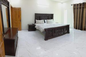 ein Schlafzimmer mit einem Bett in einem Zimmer mit Marmorböden in der Unterkunft Haven Lodge, Bahria Enclave in Islamabad