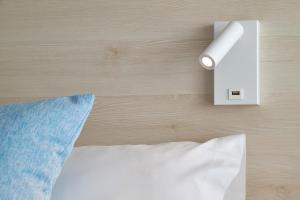 a light switch on a wall next to a bed at URH Excelsior in Lloret de Mar