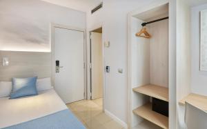 a small bedroom with a bed and a closet at URH Excelsior in Lloret de Mar