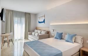 a hotel room with a large bed and a couch at URH Excelsior in Lloret de Mar