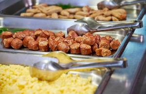 a buffet filled with different types of food with spoons at URH Excelsior in Lloret de Mar