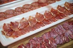 a bunch of different types of meat on plates at URH Excelsior in Lloret de Mar