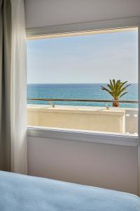 a bedroom with a window with a view of the ocean at URH Excelsior in Lloret de Mar