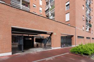 ein Backsteingebäude mit einer offenen Garage mit einem Fahrrad in der Unterkunft Casa Carlyta - Vicino Ospedale San Raffaele e Metro M2 in Vimodrone