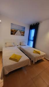 2 camas en una habitación con ventana en Apartment ALOHA Fue, en Puerto del Rosario