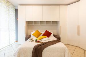 Schlafzimmer mit einem Bett mit gelben und roten Kissen in der Unterkunft Casa Carlyta - Vicino Ospedale San Raffaele e Metro M2 in Vimodrone