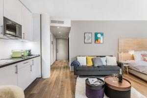 uma cozinha e uma sala de estar com um sofá e uma mesa em N20 Residence by Homenhancement em Genebra