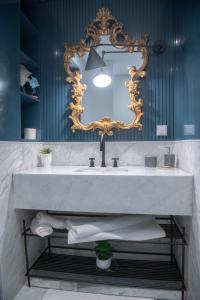 baño con lavabo grande y espejo en L'Hôtel Particulier La Marsa, en La Marsa