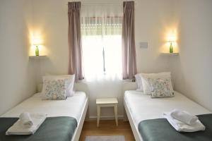 two twin beds in a room with a window at Nature et al House - Farmhouse in Batalha