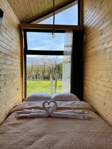 a bed in a room with a heart carved on it at Orion Cottage in Batumi