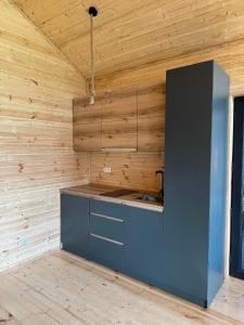 a kitchen with wooden walls and a counter with a sink at Orion Cottage in Batumi