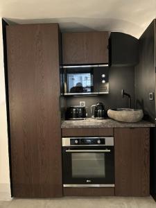a kitchen with a stove and a microwave at Studio luxe dans le vignoble in Villers-Allerand