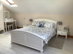 um quarto com uma cama branca e uma secretária em Byre Cottage em Alston