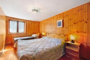 a bedroom with a bed and wood paneled walls at Casa Betulla Champorcher in Champorcher