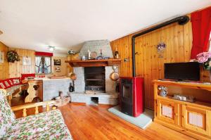 a living room with a fireplace and a tv at Casa Betulla Champorcher in Champorcher