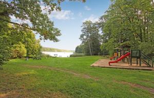 a playground in a park next to a lake at 2 Bedroom Cozy Home In Boitzenburger Land in Rosenow