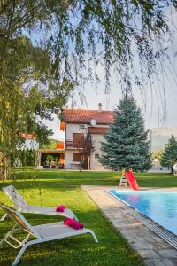 une cour avec une piscine dotée d'un toboggan et une aire de jeux dans l'établissement Villa Leko Dream House, à Cetina